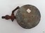 Metal of base has corroded in places. Two drilled holes are visible. The plate has been lacquered.