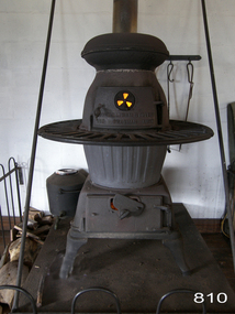 A large pot-belly stove made of grey and black coloured cast iron