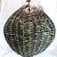 Woven cane ball, painted black, with vertical metal rod through the centre.