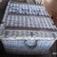 Attached to the side of the basket is a strong rope handle, There is another one on the other side. The metal straps reinforcing the lid are clearly visible.