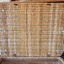 The underside of the lid is neatly finished. Here the metal reinforcing straps can be seen, three on each of the short sides of the lid. The strong timber frame can be seen around the top edges of the basket.