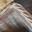 This close up photo shows the wicker attached to the wooden frame. 