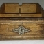 Drawer has decorative wooden trip and fancy metal plate around key hole