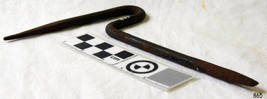 Metal rod a pointy end and a flat end, bent into a goose-neck at the centre