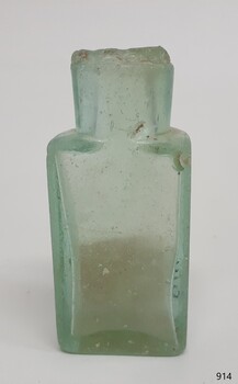 Small clear glass bottle with  green hue, chipped mouth and shoulder