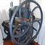 Guillotine has hears on both sides. A wooden handle is attached to the right side wheel