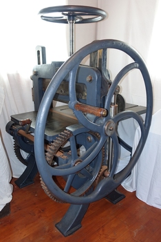 Guillotine has hears on both sides. A wooden handle is attached to the right side wheel