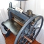 A handle is attached to the front of the bed. The top wheel is threaded at the base.