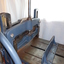 The top wheel is threaded into the central bridge over the bed. The rear vertical plate is adjustable.