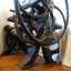 The four legs are curved. A metal axle joins the left and right wheels.