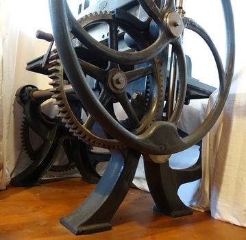 The four legs are curved. A metal axle joins the left and right wheels.