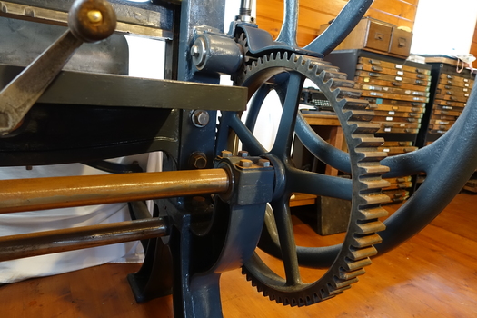 The wheel turns the cogs on the gear. The front hand winds the bed front to back