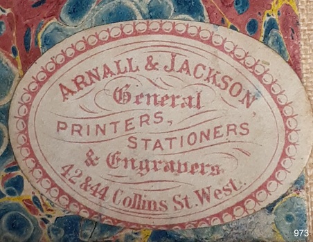 Oval label with red print showing maker's name and address