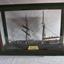 Ship model with two masts in a timber framed glass display case.