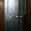 Green painted iron safe had double doors, each slightly open. There is an oval plaque on the top section of each door.