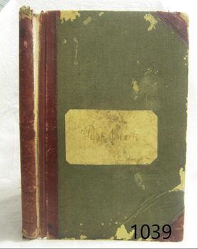 Cover has red binding and reinforced corners, and green cover. There is a label pasted on the cover with a handwritten title.