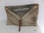 Square beige canvas bag with buckle and strap closure and, black insert flap and stamped inscription