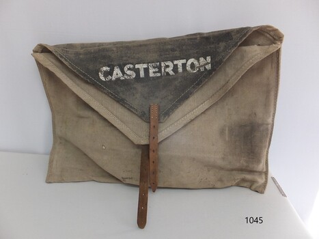 Square beige canvas bag with buckle and strap closure and, black insert flap and stamped inscription