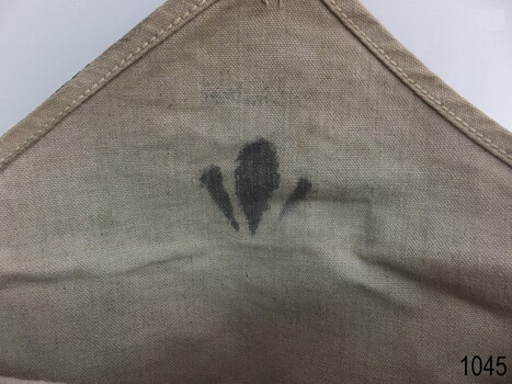 Inside the beige triangular flap is a stamped black broad arrow symbol