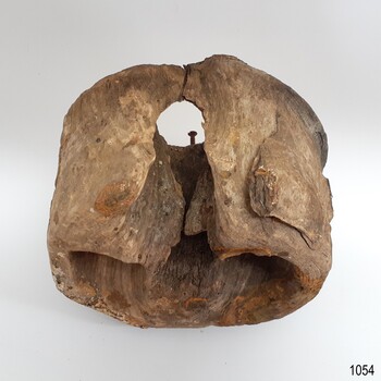 Wooden dead eye has split on the side of one hole, exposing the centre of the wood and showing the embedded nail