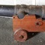 Black metal deck cannon or carronade on wooden carriage with wheels