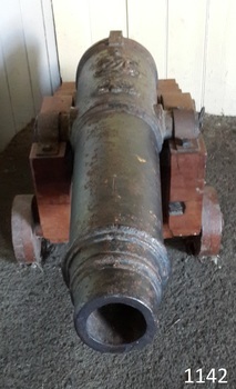 Barrel has decorative concentric rings on the outside at the front. Carriage wheels are wooden.