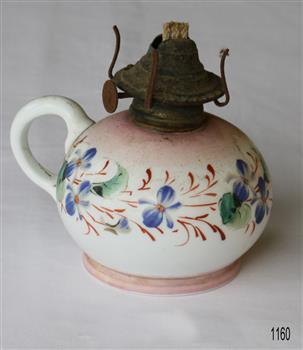 Oil lamp showing three wicks. Base is ceramic with blue flowers and green leaves on a white base. Complete with glass cover.