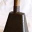 An oblong metal bell with a wooden handle.