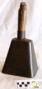 An oblong metal bell with a wooden handle.