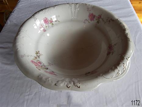 White porcelain bowl has fink and green floral motifs.