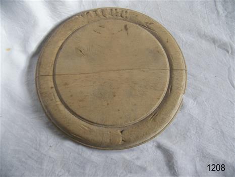 Round wooden bread board with carved inner circle and carving an outer rim in old English lettering ‘Bread’. Has crack across whole of board.