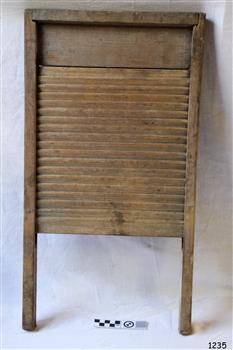 Wooden washboard with ribbed wooden grid.