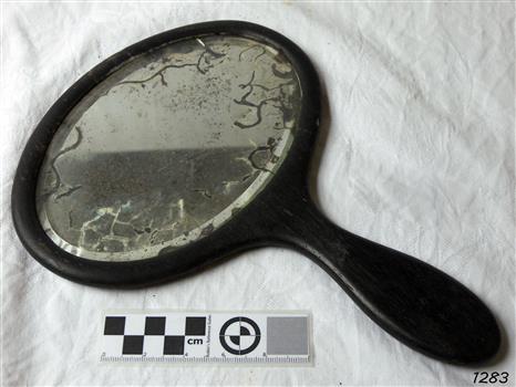 Mirror encased in wooden frame with wooden handle