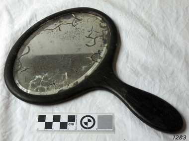 Mirror encased in wooden frame with wooden handle