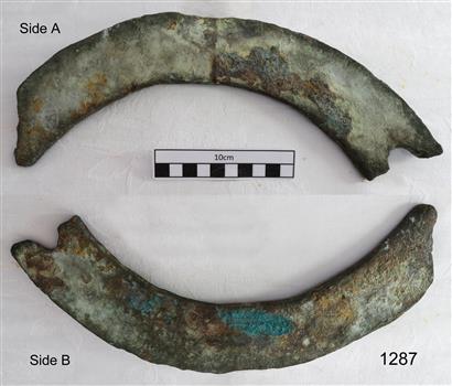 Two curved sections shaped metal with corrosion on the surface