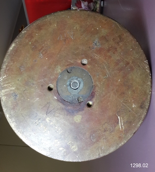 Metal base facing viewer with stamped and painted inscriptions