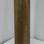 Upright shell has shiny brass outer surface with dark markings