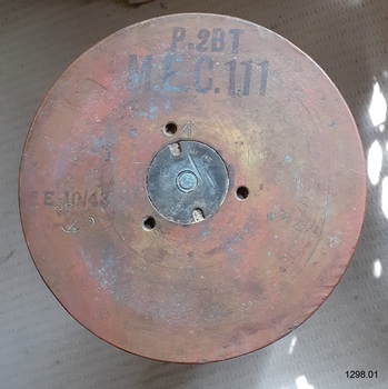 Round base facing viewer, showing inscriptions, indented circle in centre and three holes around it