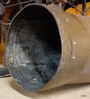 Shell laying on bench, view of edge and inside of mouth, wihci is dark metal with white chalky marks