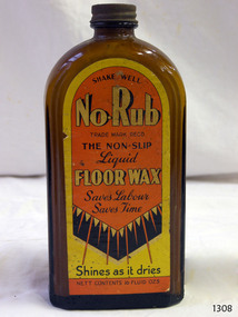 Brown glass bottle, rectangular, with yellow, orange and black label on the front