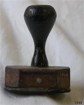 Stamp has a wooden handle and base