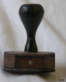 Stamp has a wooden handle and base