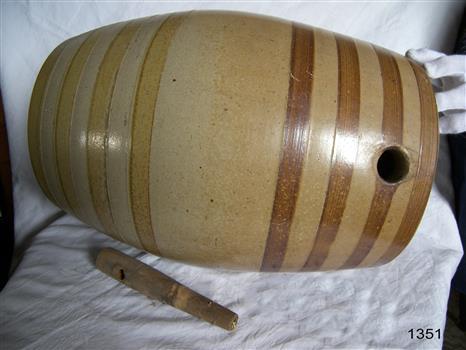 Tan coloured ceramic cask with light and dark brown rings as decoration.
