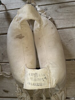 View of inscription on one of the outside shoulder straps. Stencilled with text and emblem of t a crown