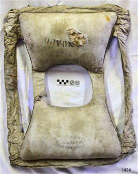 Inscriptions on front and back pockets, hole exposes kapok filling