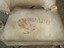 Filling showing through hole in compartment. Inscription stencilled onto canvas.