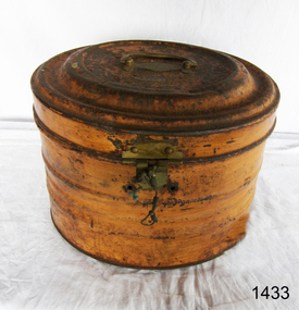 Brown painted oval metal box with attached lid, metal handle on lid, metal catch on front side