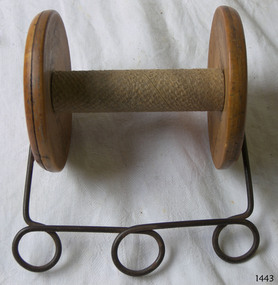 Wooden reel wit metal handle attached