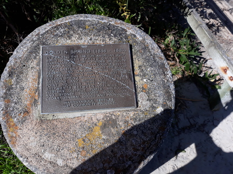 Rectangular metal plaque with inscription,  mounted on concrete