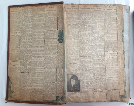 Newspaper clippings cover the inside cover and fly page